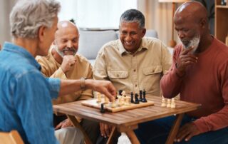 Four senior men play chess and board games at one of the best San Diego retirement communities
