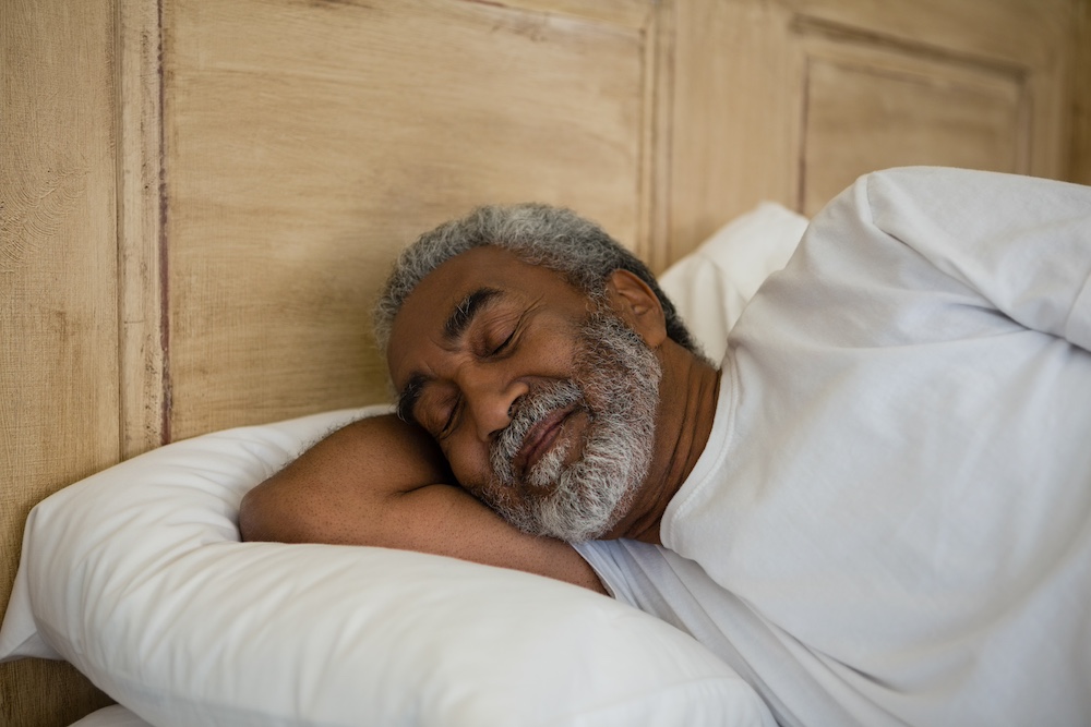 Senior man sleeping on bed in the bedroom at home