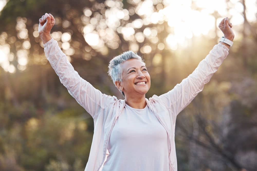 Senior with arms raised in San Diego retirement communities.