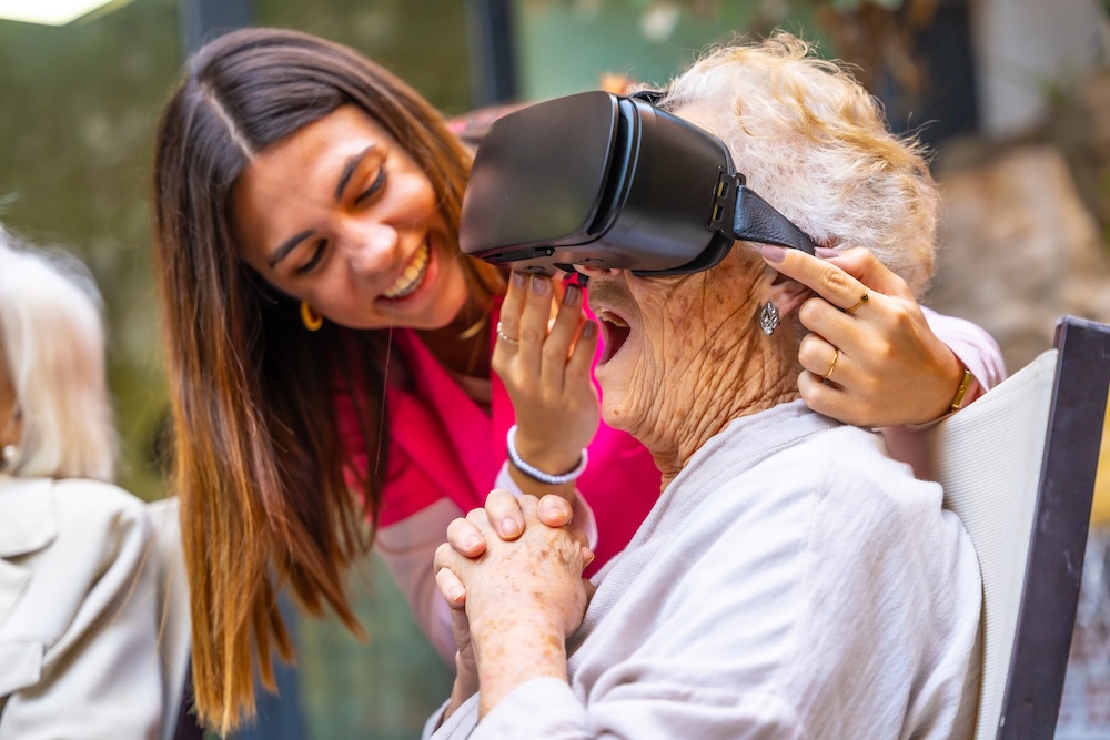 Caregiver showing a senior woman the fun that can be had with VR at senior assisted living 